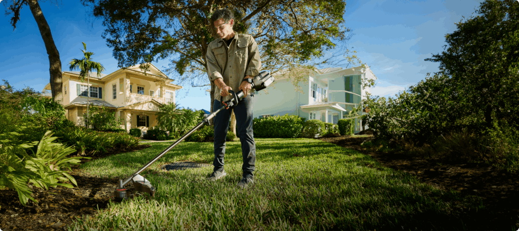 Gardener trimming a lawn edge with a Kress KG163 60 V grass trimmer