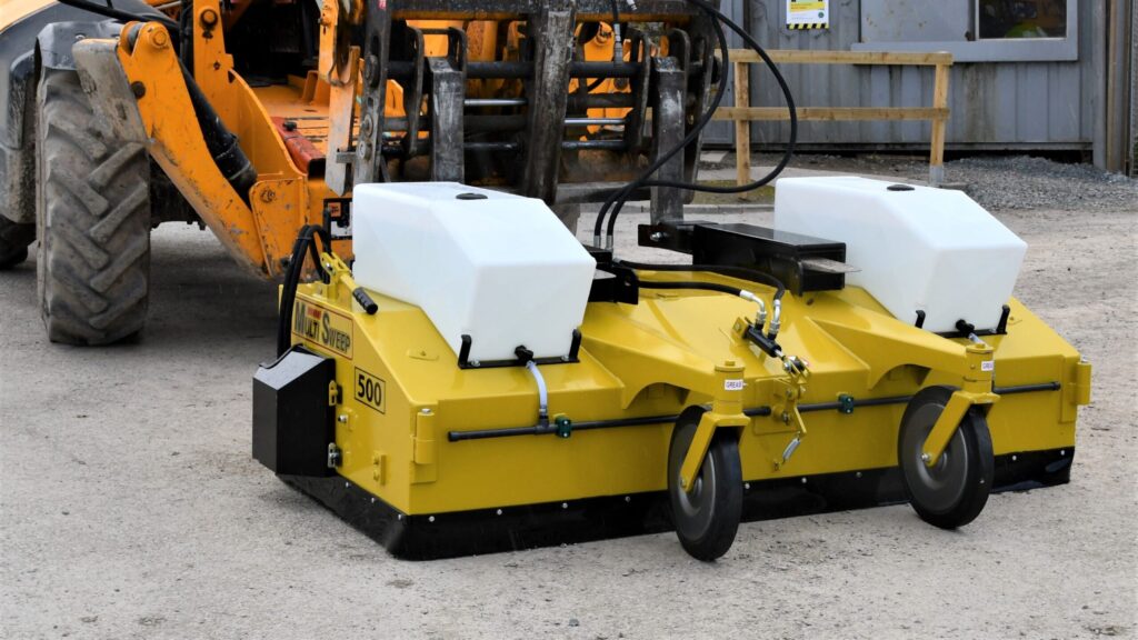 Multi Sweep 500 fork-mounted sweeper collector with twin water tanks on a loader in a yard