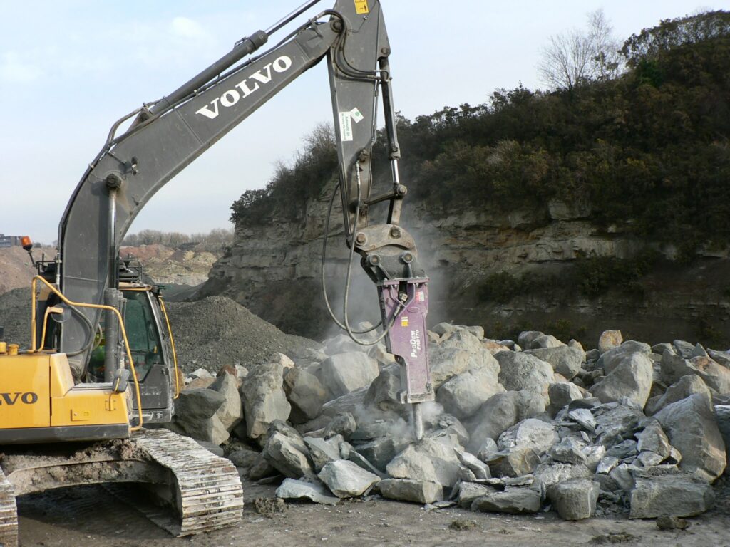 ProDem hydraulic hammer breaking rock in a quarry on a crawler excavator