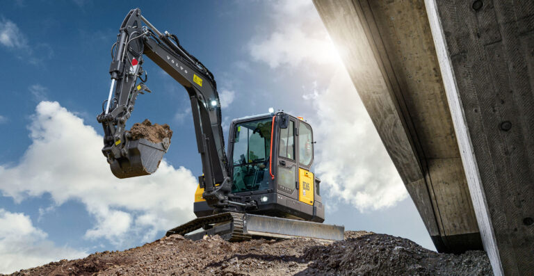 Volvo EC65 6 tonne compact excavator lifting a bucket of soil