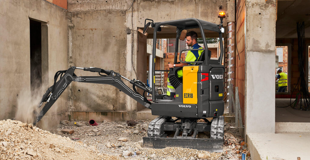 Volvo ECR18 Electric compact excavator breaking concrete inside a building